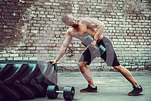 Athletic man working out with a dumbbell. Strength and motivation. Exercise for the muscles of the back