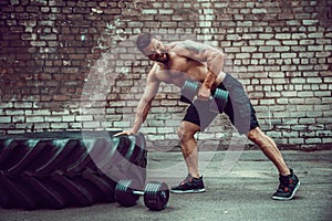 Athletic man working out with a dumbbell. Strength and motivation. Exercise for the muscles of the back