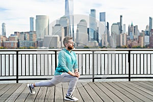 Athletic Mature Fit Man Doing Exercises in City outdoor. Happy man workout in New York city. Senior man training legs