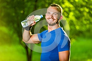 Athletic mature man drinking water from a bottle