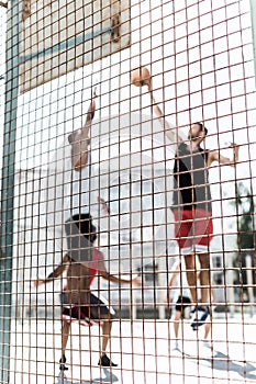 Athletic men playing basketball together on court