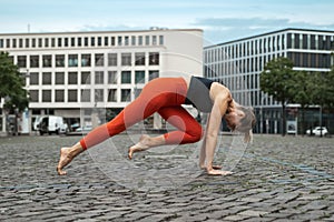 Athletic middle-aged woman is engaged in fitness, on the street in the city