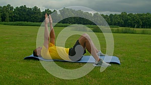 Athletic motivated African American man doing bodyweight back workout in park