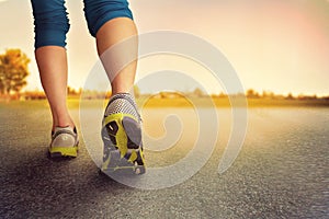 An athletic pair of legs on pavement during sunrise or sunset -