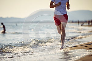 Athletic people jogging on beach enjoying the sun exercising their healthy lifestyle