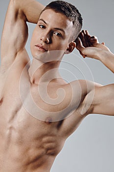 athletic physique young male nude torso gray background portrait