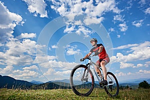 Athletic professional sportsman cyclist in sportswear and helmet cycling cross country bike