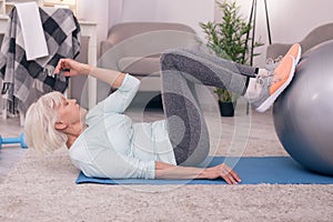 Athletic senior woman working out her abs