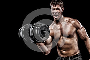 Athletic shirtless young sports man - fitness model holds the dumbbell in gym. Copy space fore your text.