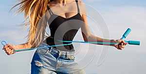 Athletic slim woman measuring her waist by measure tape after diet. Slim body, jump rope. Girl with perfect waist with a