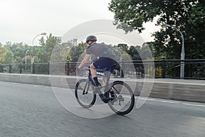 Athletic sportsman riding professional bike in race on a road.