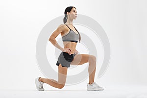 Athletic sportswoman doing lunge exercise