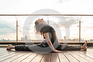 Athletic Sporty Man Doing Splits And Stretching Outdoors On Urban Background With Sunset. Hanumanasana
