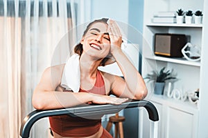 Athletic and sporty woman running on treadmill running machine at gaiety home.