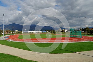 Athletic stadium in a city in Eastern Europe. On the background there are mountains covered by forests.