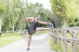 Athletic strong man doing stretches before exercising, outdoor.