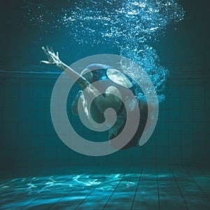 Athletic swimmer doing a somersault underwater
