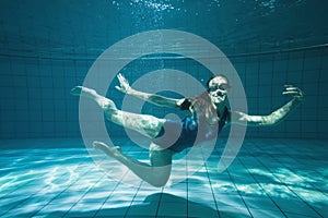 Athletic swimmer smiling at camera underwater