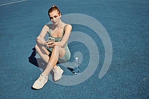 athletic woman in activewear sitting next