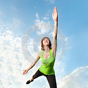 Athletic woman balancing in front of blue sky