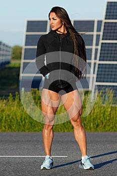 Athletic woman with big quads. Muscular girl posing outdoor, muscular legs photo