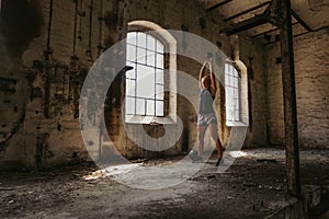 Athletic woman doing kettlebell swing in an old building