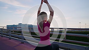 athletic woman is doing morning workout and yoga asana outdoors in city