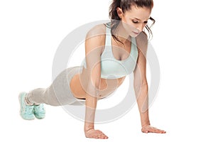 Athletic woman doing push-ups on a white background