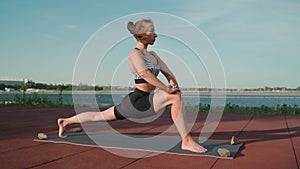 Athletic Woman Doing Yoga Lake Background. Beautiful Girl Is Exercising Outdoors