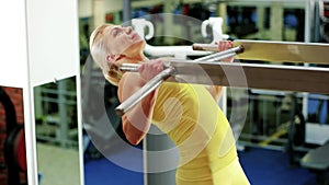 Athletic woman at the gym, girl performs a pulling up exercise, exercises on the horizontal bar, playing sports as a