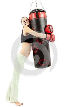 Athletic woman hugging a punching bag