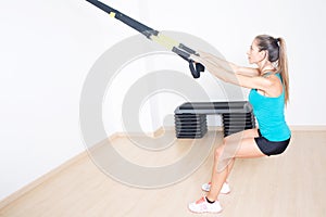 Athletic woman makes TRX exercise