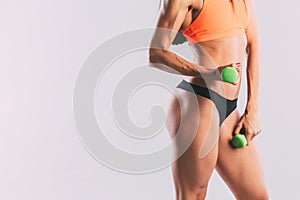 Athletic woman pumping up muscles with dumbbells.