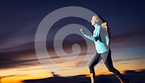 Athletic woman running at sunset dusk