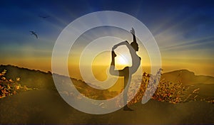 Athletic woman silhouette on a cliff, yoga pose at sunset, meditation in nature