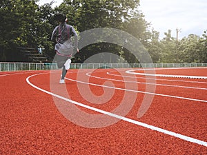 Athletic woman in sport clothes running on stadium track. Female runner jogging for exercise. Workout Healthy lifestyle conceptAth