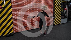 An athletic woman in sportswear jumps on a jump rope in a sports boxing gym.