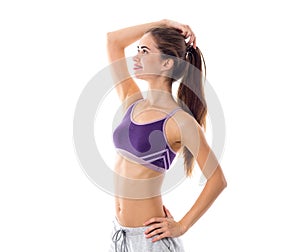 Athletic woman in sportswear standing sidewise