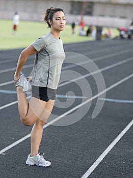 Athletic woman stretching leg muscles