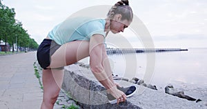 Athletic woman tying her laces before running