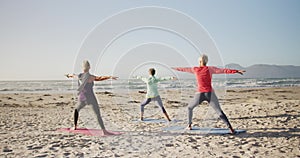 Athletic women performing yoga in the beach