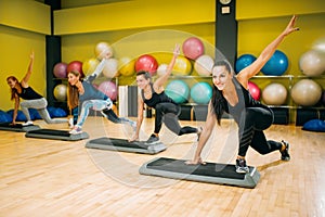Athletic women on step aerobic workout indoor