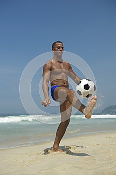 Athletic Young Brazilian Man Juggling Football Beach