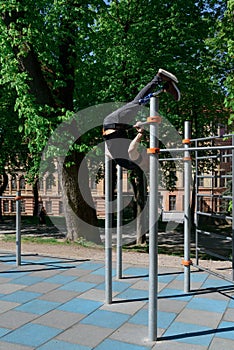 athletic young man with artificial leg working out on a bars