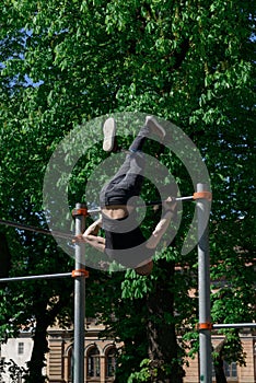 athletic young man with artificial leg working out on a bars