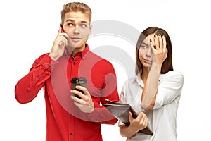 Athletic young man with blond hair talking on the phone with Cup of coffee in his hands