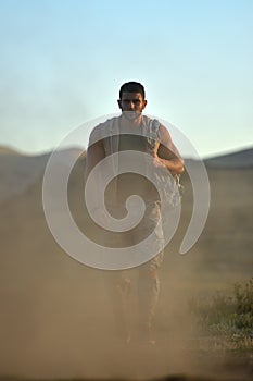 Athletic young man on dusty field