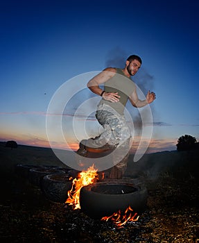 Athletic young man exercising on dusty field