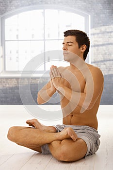 Athletic young man exercising yoga