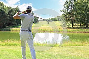 Athletic young man playing golf in golfclub photo